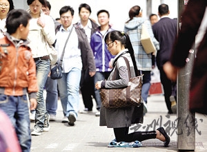 女子背名貴挎包跪地乞討稱只求3元或路費(fèi)(圖)
