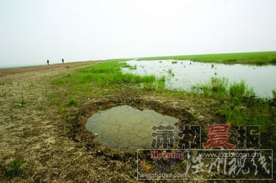 昨日，岳陽(yáng)東洞庭湖，干裂的湖床上漁民挖的儲(chǔ)水井。圖/記者韓敬宇