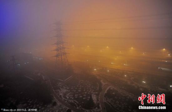 剛告別初雪，京城陷入“霧區(qū)”。2011年12月4日晚，北京阜石路石景山區(qū)楊莊段，被大霧籠罩。李文明 攝 CFP視覺中國(guó)