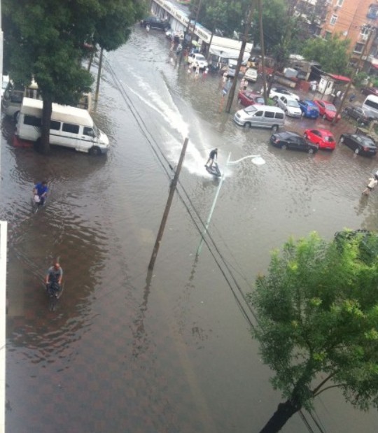 天津大雨過后 男子馬路上開摩托艇(圖)
