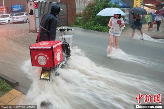 2012年7月21日，北京普降暴雨，朝陽(yáng)區(qū)北部立水橋南地區(qū)積水嚴(yán)重。一小區(qū)門口，積水沿斜坡形成巨大水流，阻礙人們通行。