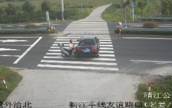 女子騎摩托車(chē)玩手機(jī)被撞飛